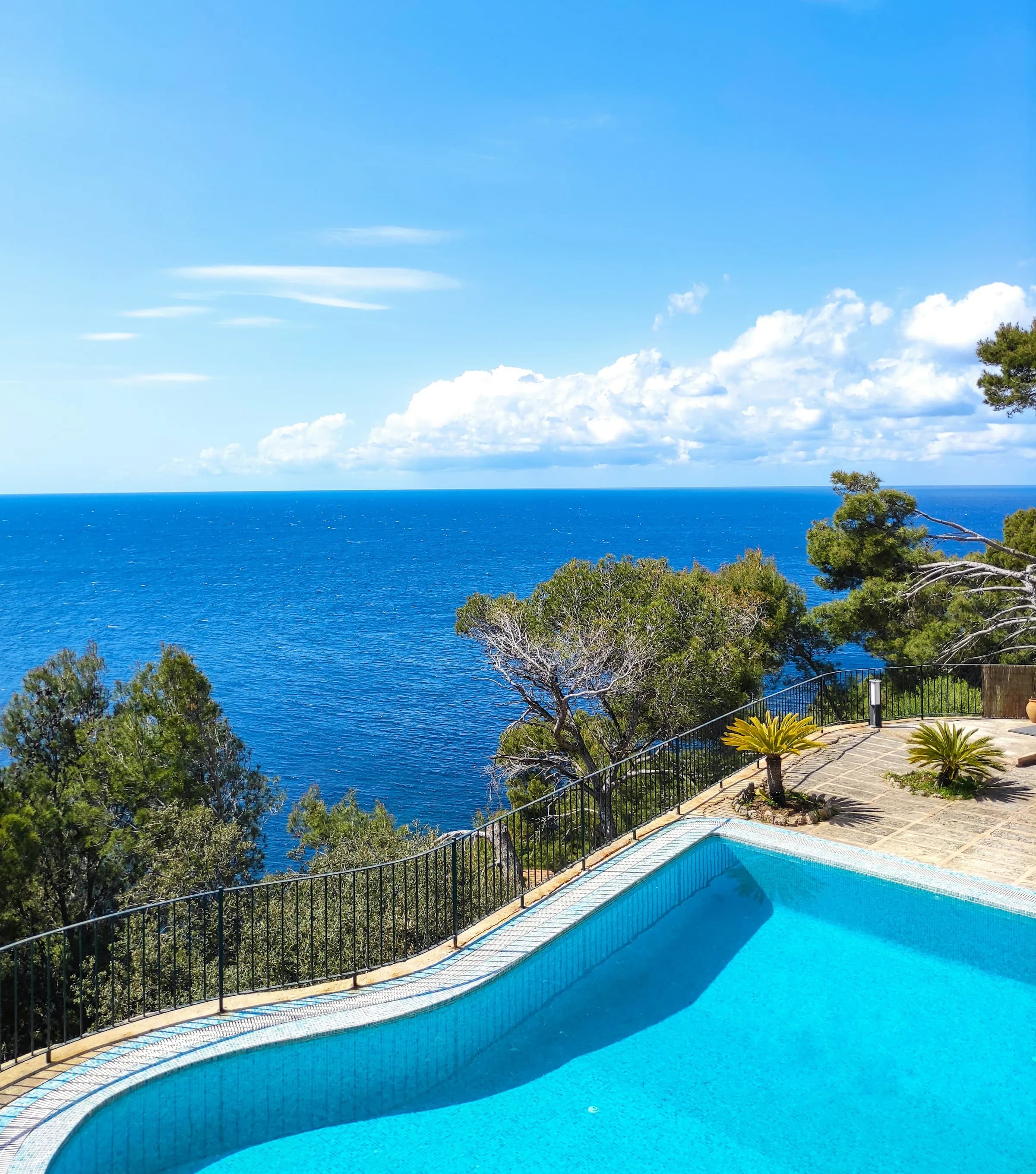 A blue swimming pool overlooking the sea